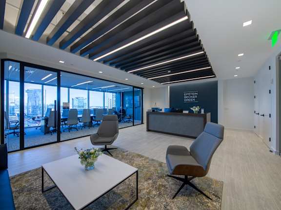 A modern office space with a glass wall and a reception desk.