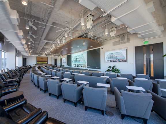 A conference room with rows of chairs facing a screen.