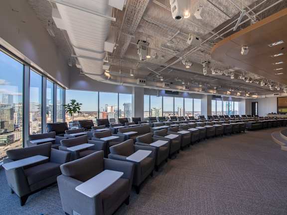 A conference room with grey chairs and a carpeted floor.