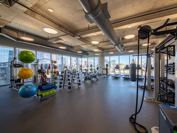 A gym with a variety of equipment and a view of the city.