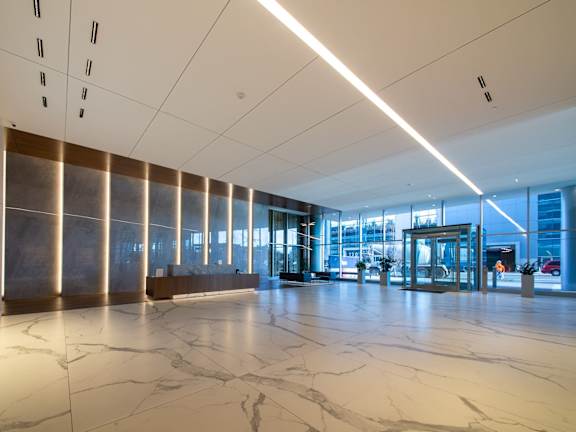 A large, modern hallway with marble floors and a colorful mural on the wall.