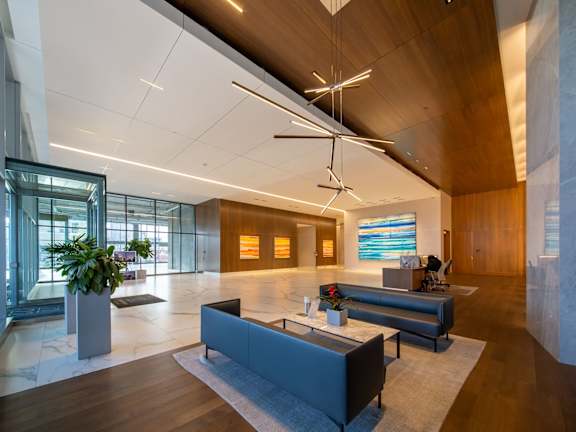 A modern office lobby with a wooden ceiling and a large glass wall.