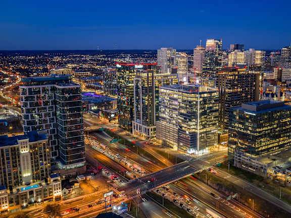 A cityscape at night with illuminated buildings and roads.