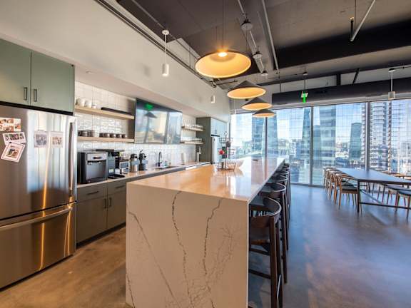 A modern kitchen with a marble island and stainless steel appliances.