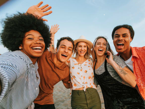 a group of friends posing for a photo on the beach