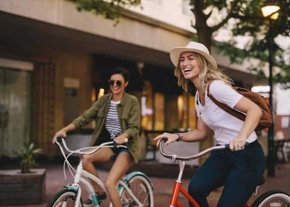 Two people riding bicycles in an urban setting.