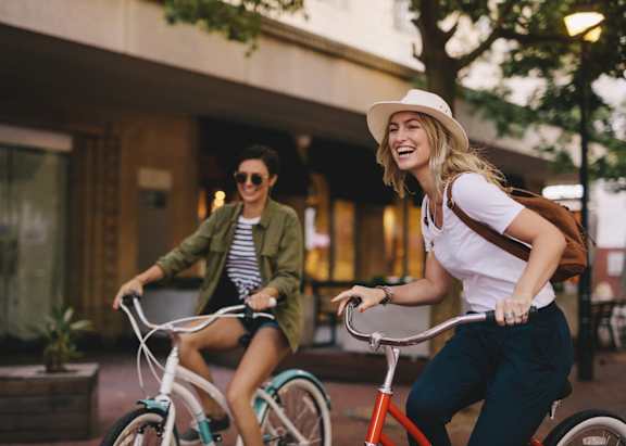 Two people riding bicycles in an urban setting.