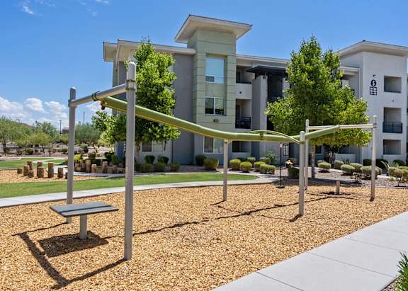 A playground with a yellow slide and red and blue play structures.