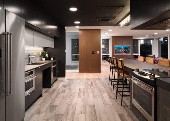 a kitchen with stainless steel appliances and a large island with chairs