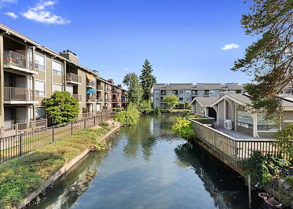 A canal runs through a residential area with houses on both sides.