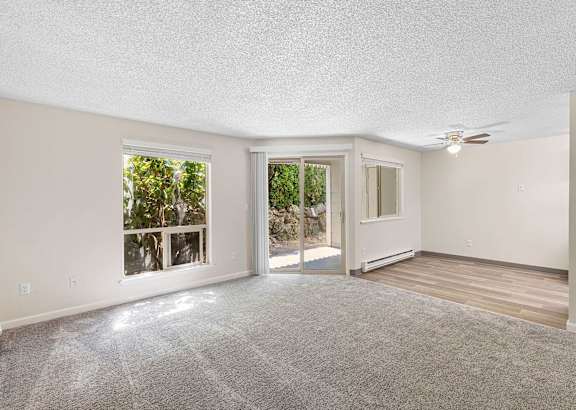 A living room with a white couch and grey pillows.