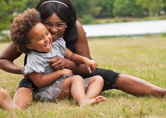 a mother playing with her child on the grass