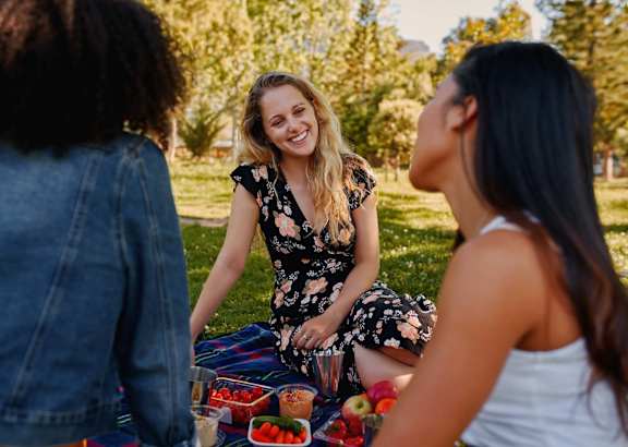 Three women having a picnic in a park.