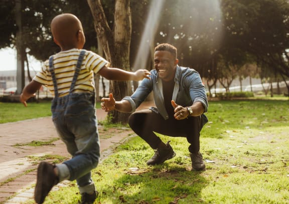 a man playing with a young boy in a park
