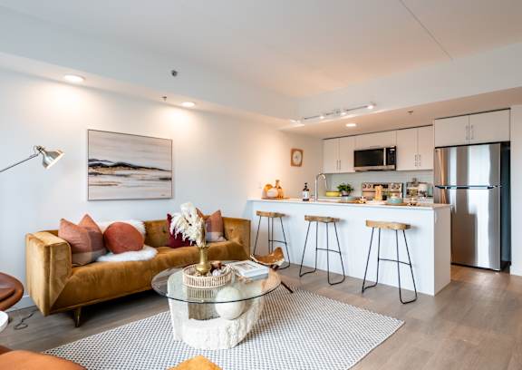A modern kitchen with a dining area and a living room.