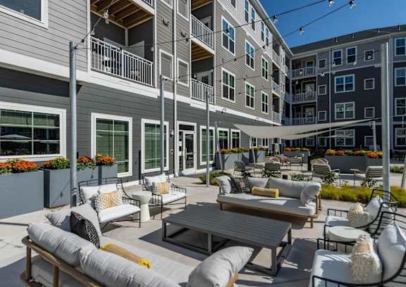 A patio with a table and chairs is surrounded by buildings.