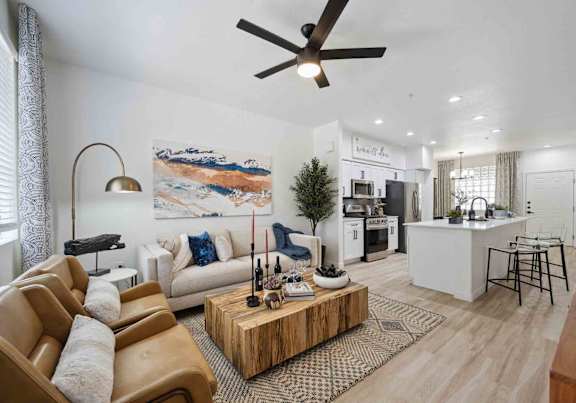 A living room with a white couch, a wooden coffee table, and a ceiling fan.