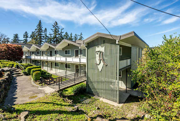 A row of houses with a stone wall in front.