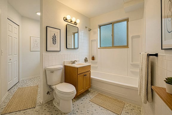 A white toilet is in a bathroom with a window.
