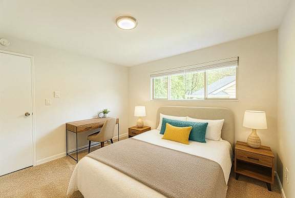 A bedroom with a bed, desk, and chair.