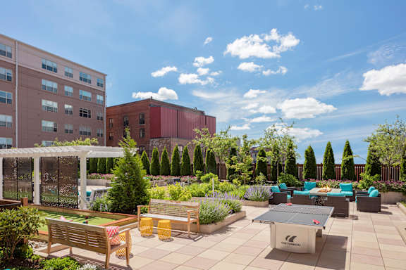 A sunny day at the rooftop garden with a variety of seating options and greenery.