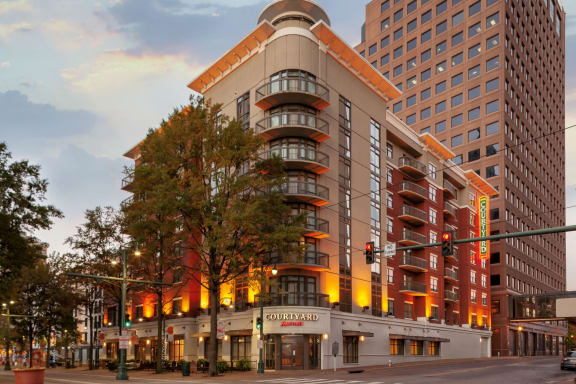 a hotel building on the corner of a city street at sunset