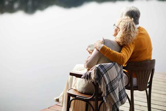 a couple sitting on a couch with their dog