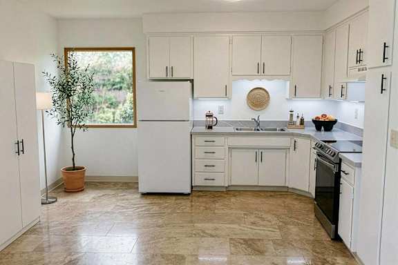 A kitchen with white appliances and cabinets.