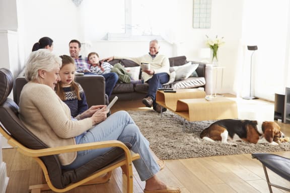 a family sitting in a living room with a dog