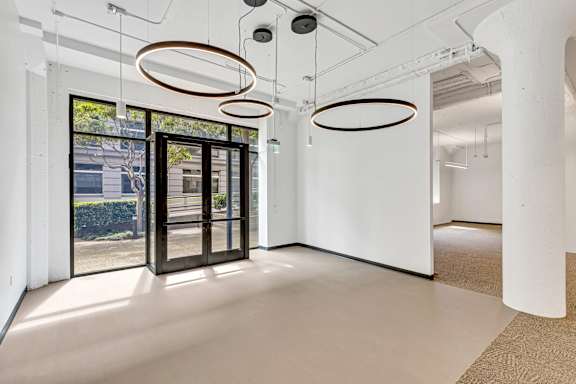A white room with three circular light fixtures hanging from the ceiling.