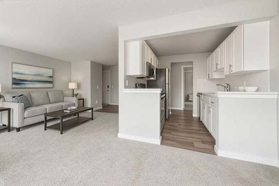 A well-lit, spacious kitchen and living room with a grey carpet.