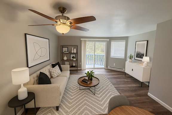 A living room with a beige couch, a coffee table, and a ceiling fan.