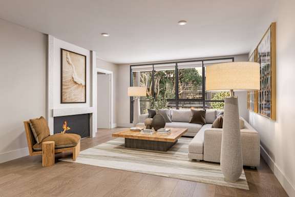 A modern living room with a fireplace, a sofa, a chair, and a rug.