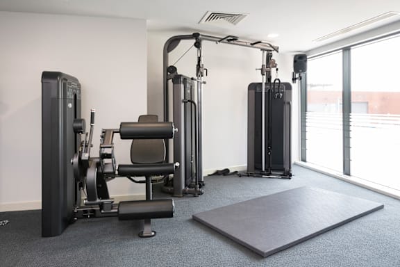A gym with a variety of equipment including a squat rack, a leg press machine, and a bench press. at The Trilogy Apartments, Manchester, M15 4RU