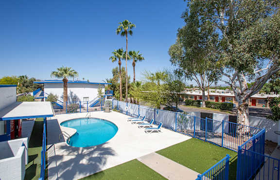 a resort style pool with chaise lounge chairs and grassy area