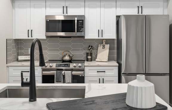 A modern kitchen with a stove, oven, and refrigerator.