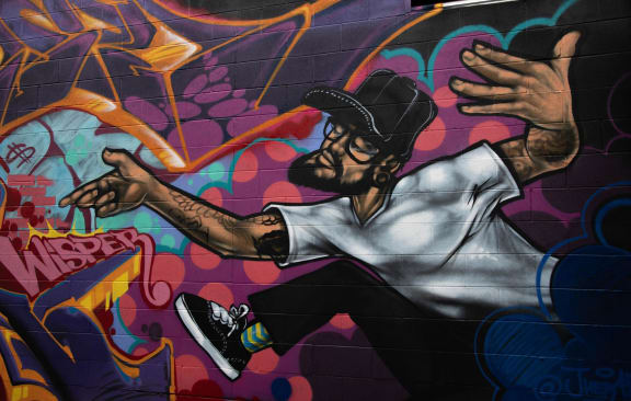 a mural of a man with his arms out on a wall