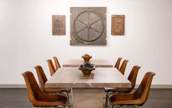 a dining room with a table and chairs and paintings on the wall at The Mill at Prattville, Prattville, Alabama, 36067