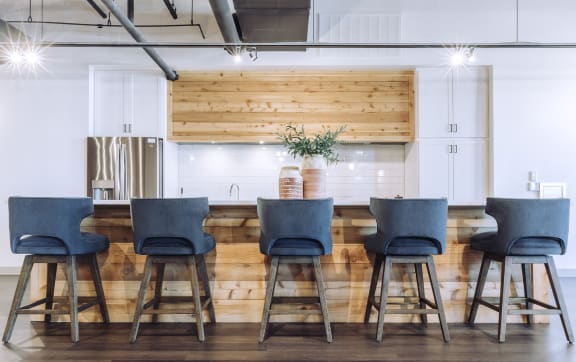 a kitchen with a long table with blue chairs at The Mill at Prattville, Alabama