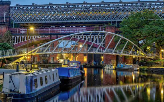 A bridge over a body of water with boats docked underneath.