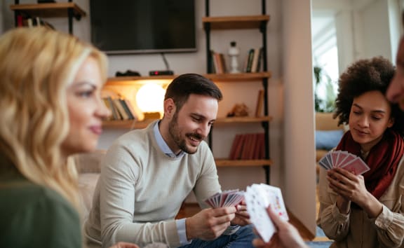 a group of people playing cards in a living room