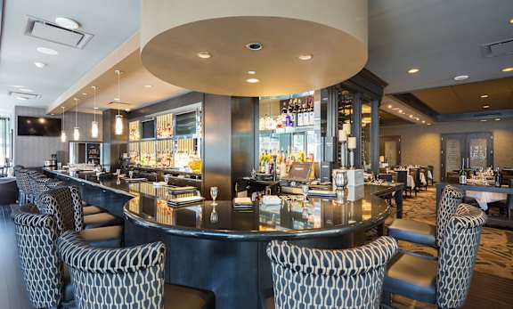 A restaurant with a bar and chairs.