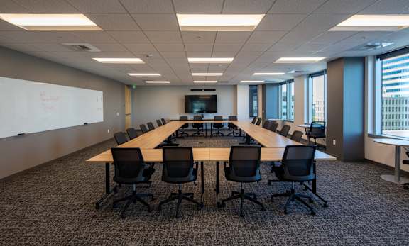 A conference room with a long table and chairs.