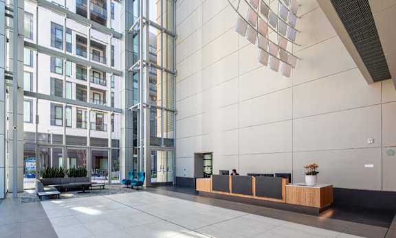 A modern building with a glass facade and a reception area with a long counter.