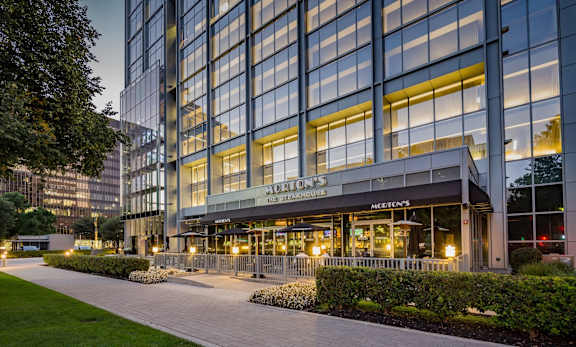 The image shows a modern building with a glass facade and a sign that reads "The Steps".