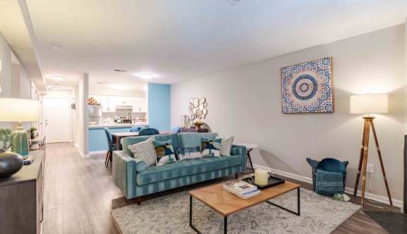 A living room with a blue couch and a television on a wooden cabinet.