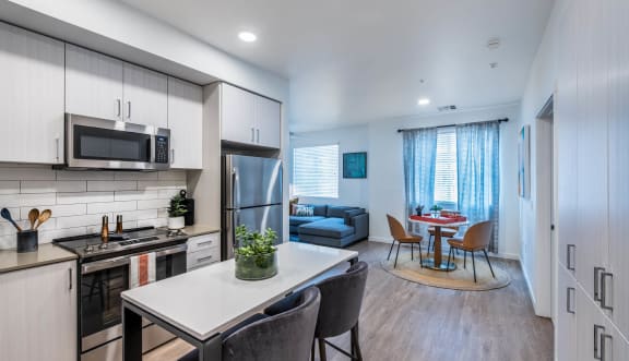 a kitchen and living room with a table and chairs