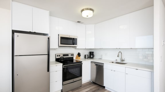 a kitchen with white cabinets and stainless steel appliances