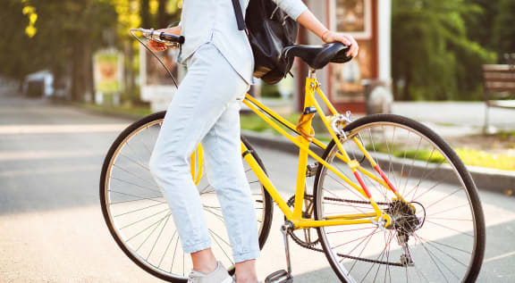 a woman riding a yellow bike on a city street