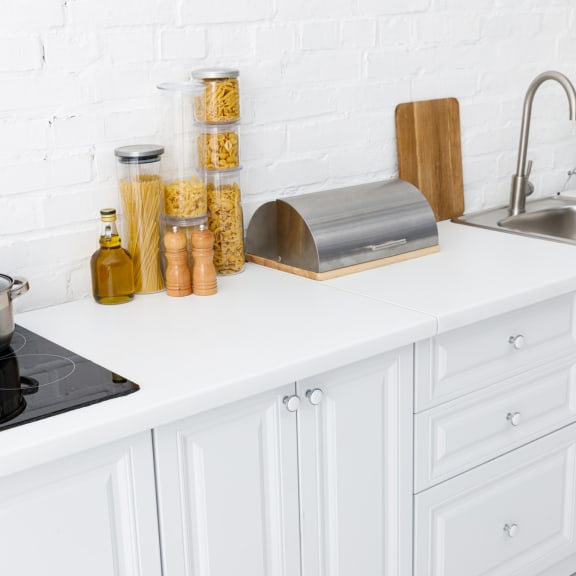a kitchen with white cabinets and a stainless steel sink
